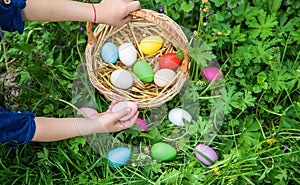 The child holds Easter eggs in his hands. Selective focus.