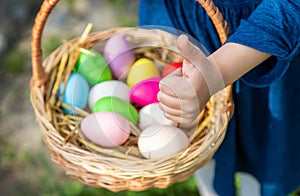 The child holds Easter eggs in his hands. Selective focus.