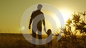 Child holds father`s hand. dad and baby are resting in the park. child plays with his father. little daughter and dad