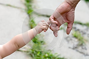 Child holds the finger of a hand