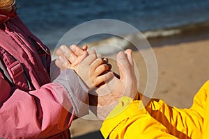 Child holds hand of adult.