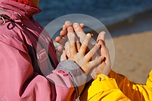 Child holds hand of adult.