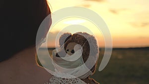 Child holds his beloved teddy bear in a protective mask during quarantine. a girl carries in her hand toy teddy bear