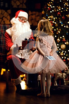 A child holds a medical mask behind his back and wants to present it to Santa Hygiene in an epidemic pandemy