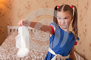 Child holds panty liners in her hand.