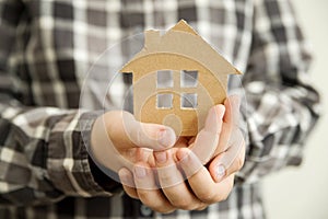 Child holds paper house. Loan for new house theme. Financial operations.