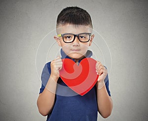 Child holds red heart