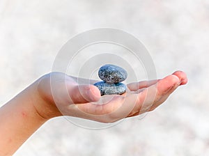 A child holds two pebbles