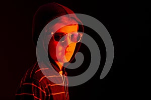 Child with hoodie and sunglasses on black background