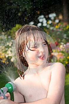 Child hosepipe water summer garden splash photo