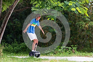 Child on hover board. Kids riding scooter