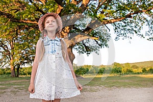 Child and a huge tree in the forest. old oak and a little girl