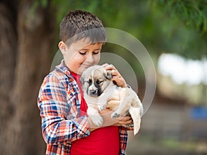 Child is hugging a little puppy. Kids love animals