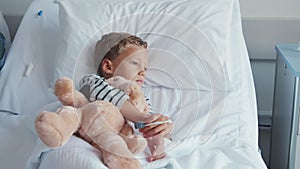 Child hugging teddy bear at hospital