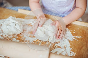 Child human hands sculpts a dough