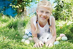 Child hunted on Easter egg in blooming spring garden.