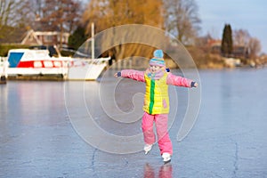 Child ice skating on frozen mill canal in Holland.