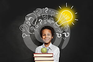 Child and Idea concept. Smart boy student with lightbulb and question marks