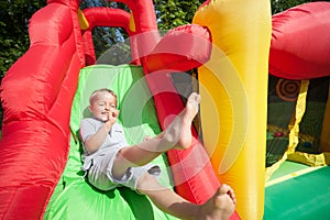 Child on inflatable bouncy castle slide