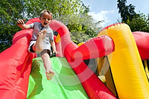 Child on inflatable bouncy castle slide photo