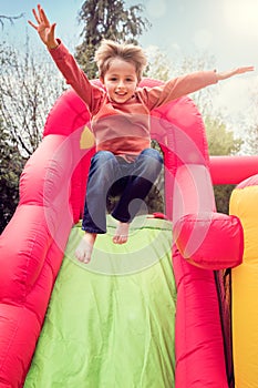 Child on inflatable bouncy castle slide photo