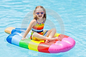 Child on inflatable float in swimming pool.