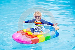 Child on inflatable float in swimming pool.