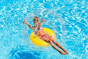 Child on inflatable ring in swimming pool