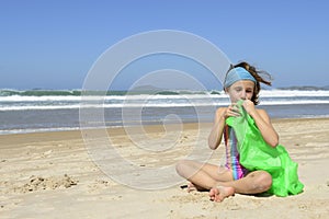Child inflating inflatable swim ring on the beach