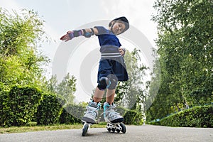 Child on inline skates in park. Kids learn to skate roller blades. Little girl skating on sunny summer day. Outdoor activity for