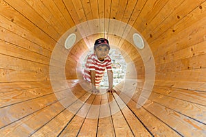 A child inside a wooden loud speaker. Casual portrait.