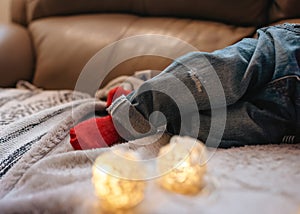 child in jeans and red socks sleeping on sofa