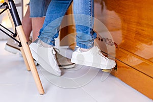 Child in jeans and sneakers press the piano pedal.