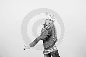 Child in jeans suit, hat, plaid shirt on orange background