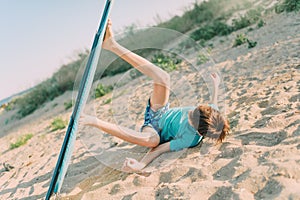 A child jokingly rides on an ironing board instead of a surfboard