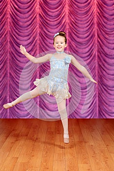 Child jumping ballerina dancer on stage