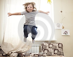 Child jumping on the bed in the bedroom