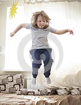 Child jumping on the bed in the bedroom