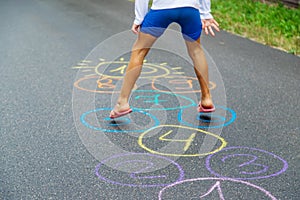 Child jumping classics on the pavement. Selective focus