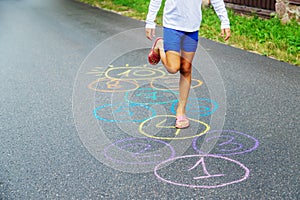 Child jumping classics on the pavement. Selective focus