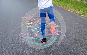 Child jumping classics on the street. Selective focus.