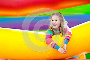 Child jumping on colorful playground trampoline