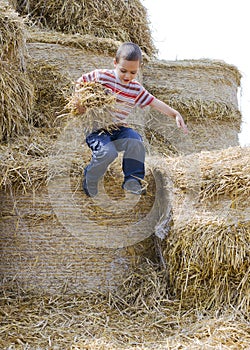 Child jumping in haystack