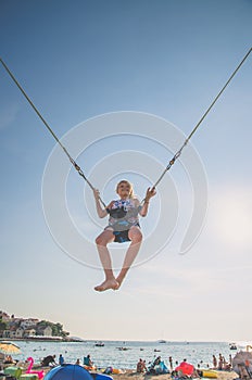 Child jumping in the jumping attraction in the seaside beach
