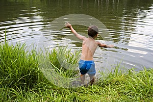 Child jumping into lake or pond