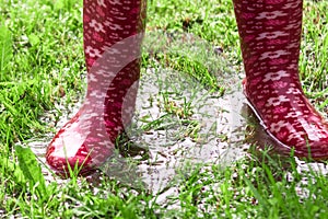 Child is jumping and playing in water pool on a grass