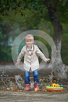 A child jumping in the puddle just after rain