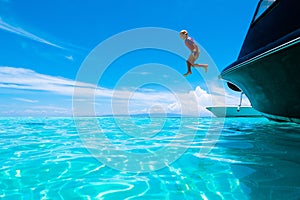 Child jumping into sea water. Yacht vacation