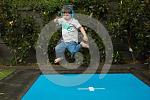 Child jumping on the trampoline - kids listening to music