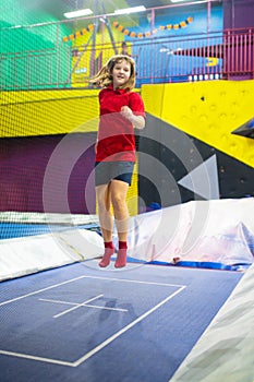 Child jumping in trampoline park. Bounce fun